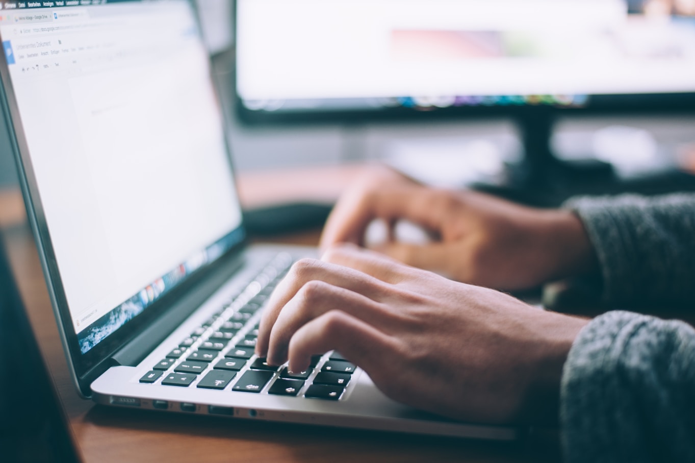 Hands typing on a laptop computer